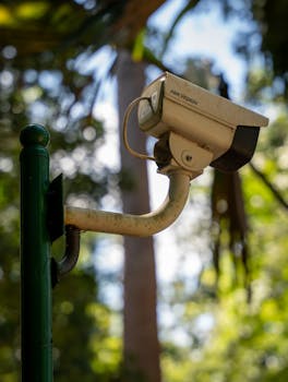 公園の緑のポールに取り付けられた監視カメラのクローズアップ。